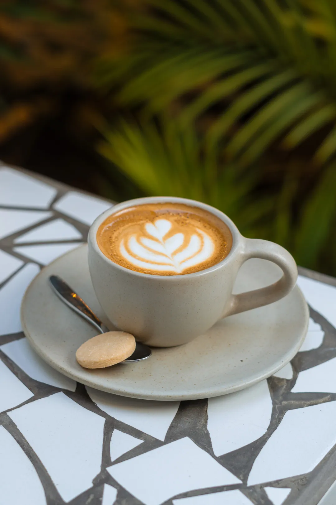 Cortado con arte latte sobre mesa de mosaico
