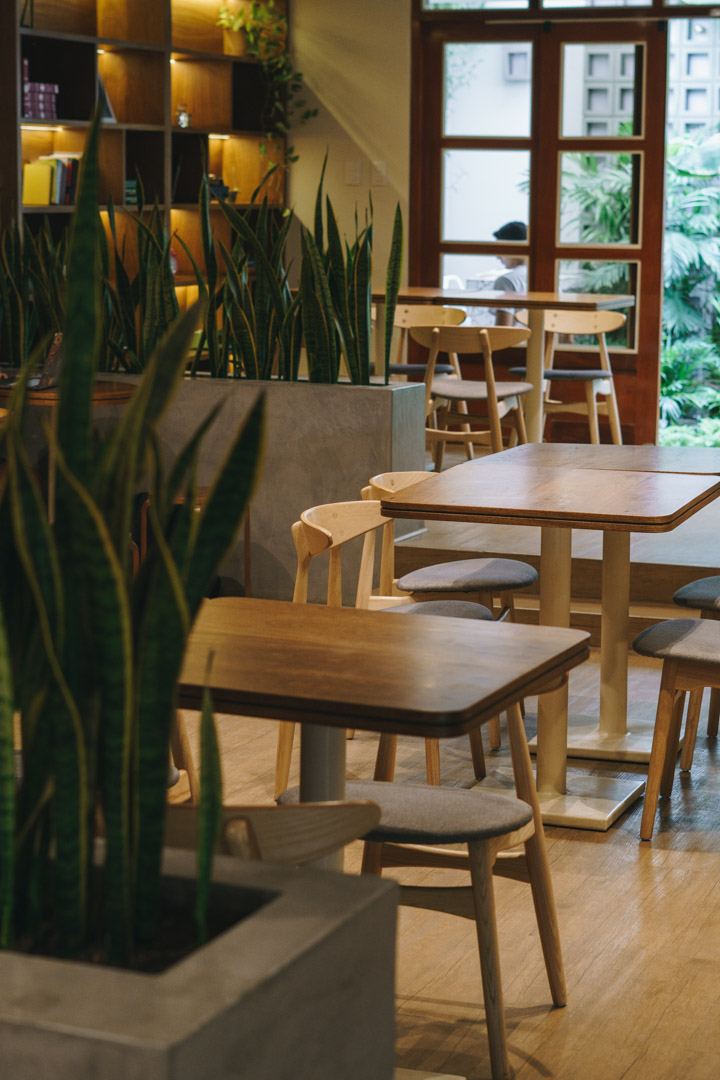 Mesas de madera y plantas en el interior de Masaro